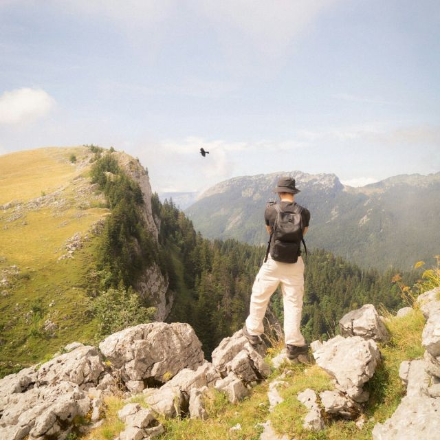 Hiker with the Trail 18L on a limestone lookout above the forest